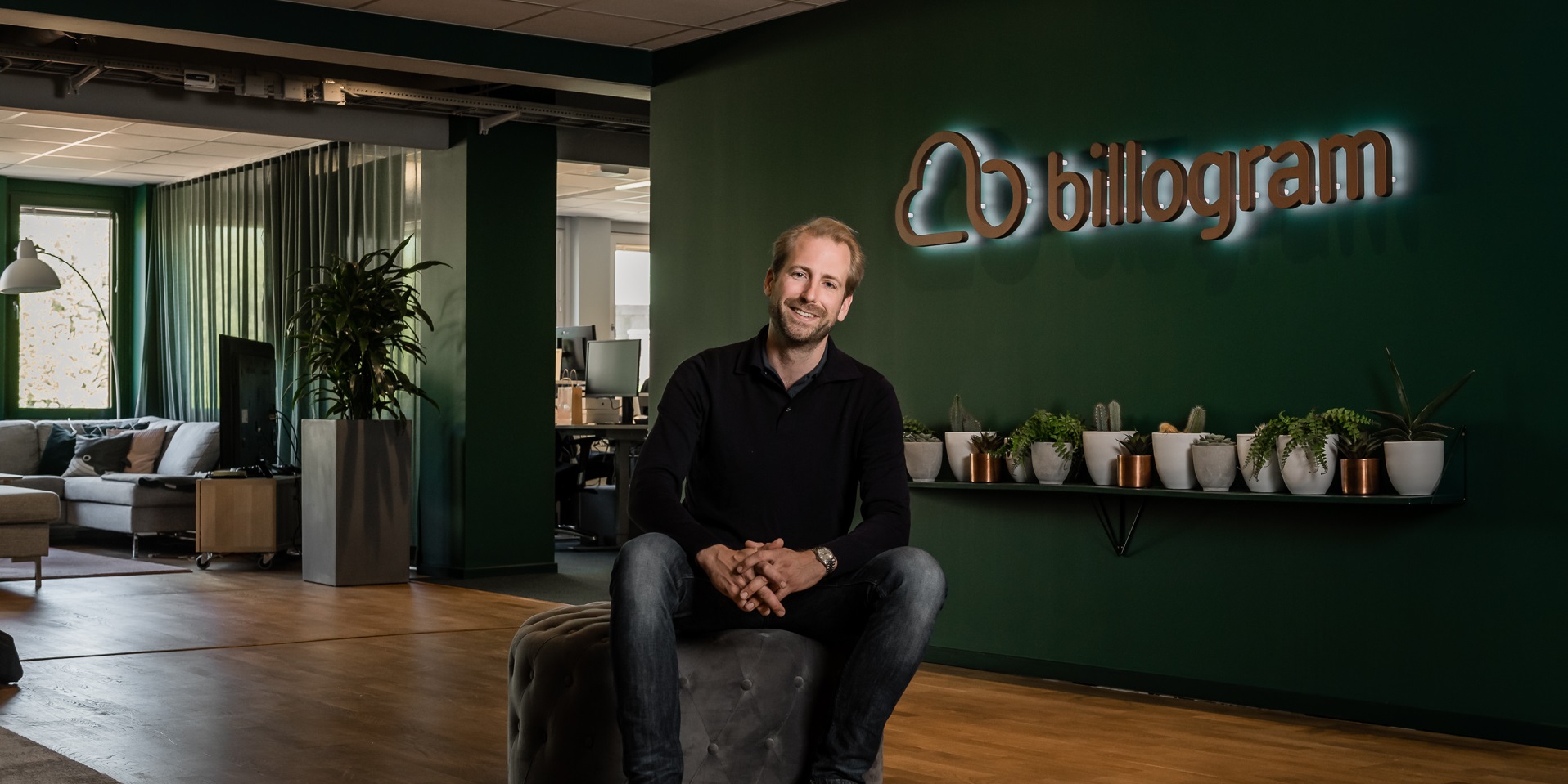 Jonas Suijkerbuijk seated in Billogram's office, under the company's sign